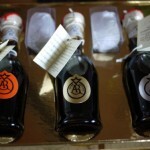 Set of luxury balsamic vinegar bottles with colored labels on a gold tray.