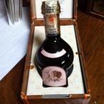 Bottle of traditional balsamic vinegar from Modena in a decorative box on a wooden table.
