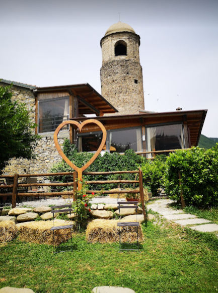 The cozy interior of the Agriturismo Montagna Verde restaurant, with its stone walls and wooden beams, exuding rustic charm. The dining area offers stunning views of the surrounding Tuscan landscape, enhancing the dining experience
