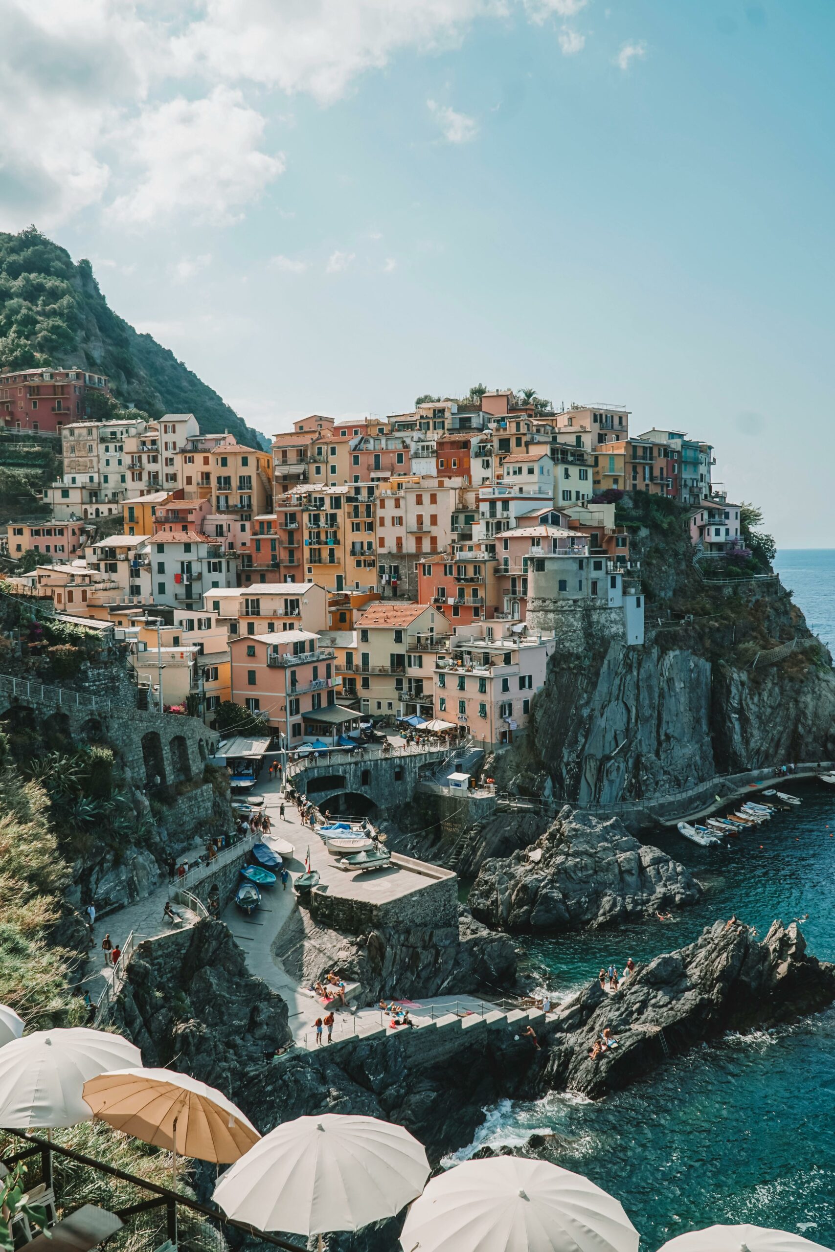 Colorful cliffside village in Cinque Terre, Italy, overlooking the sea with vibrant buildings and rocky shoreline.