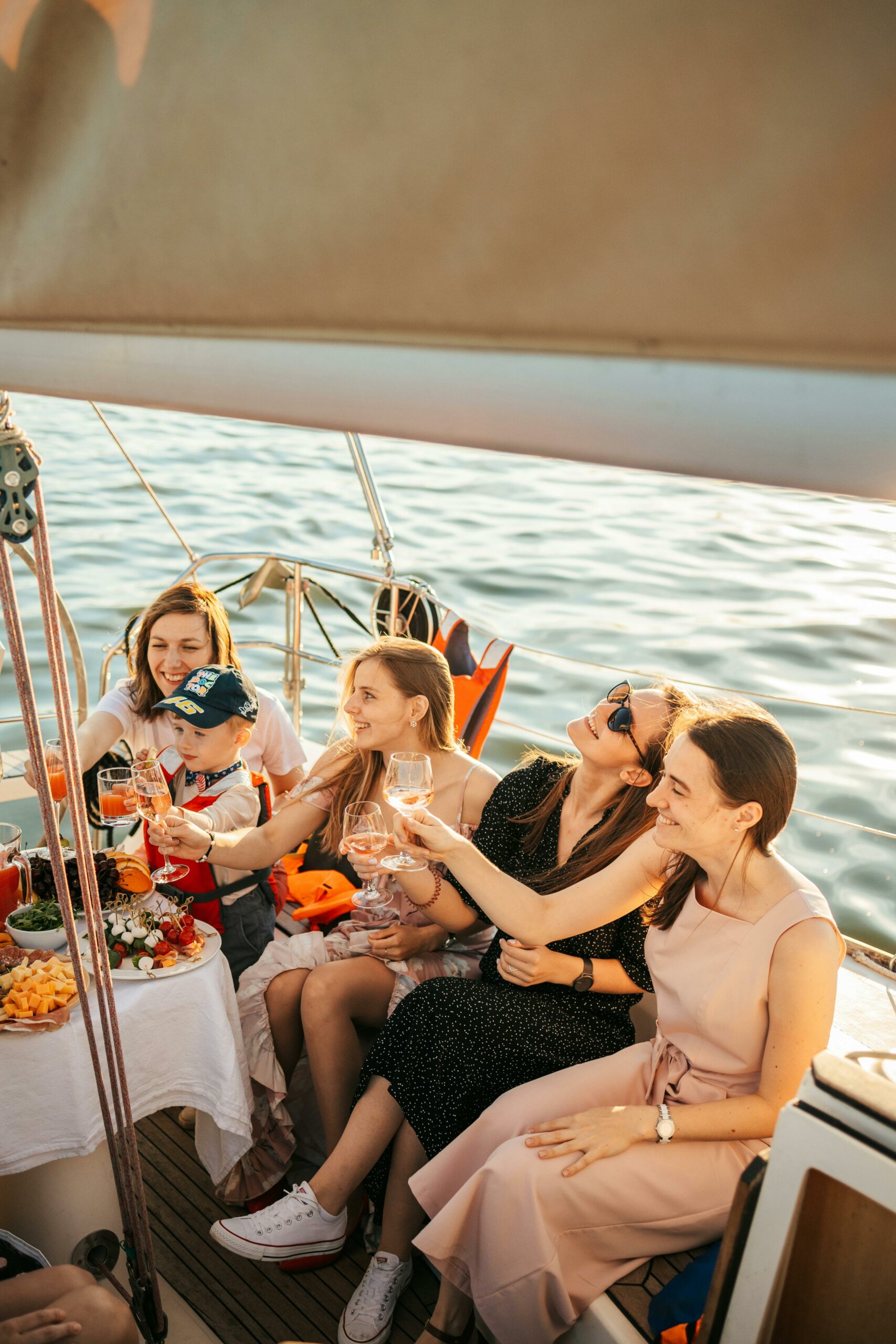 Group enjoying drinks and snacks on a boat, celebrating a sunny day at sea.